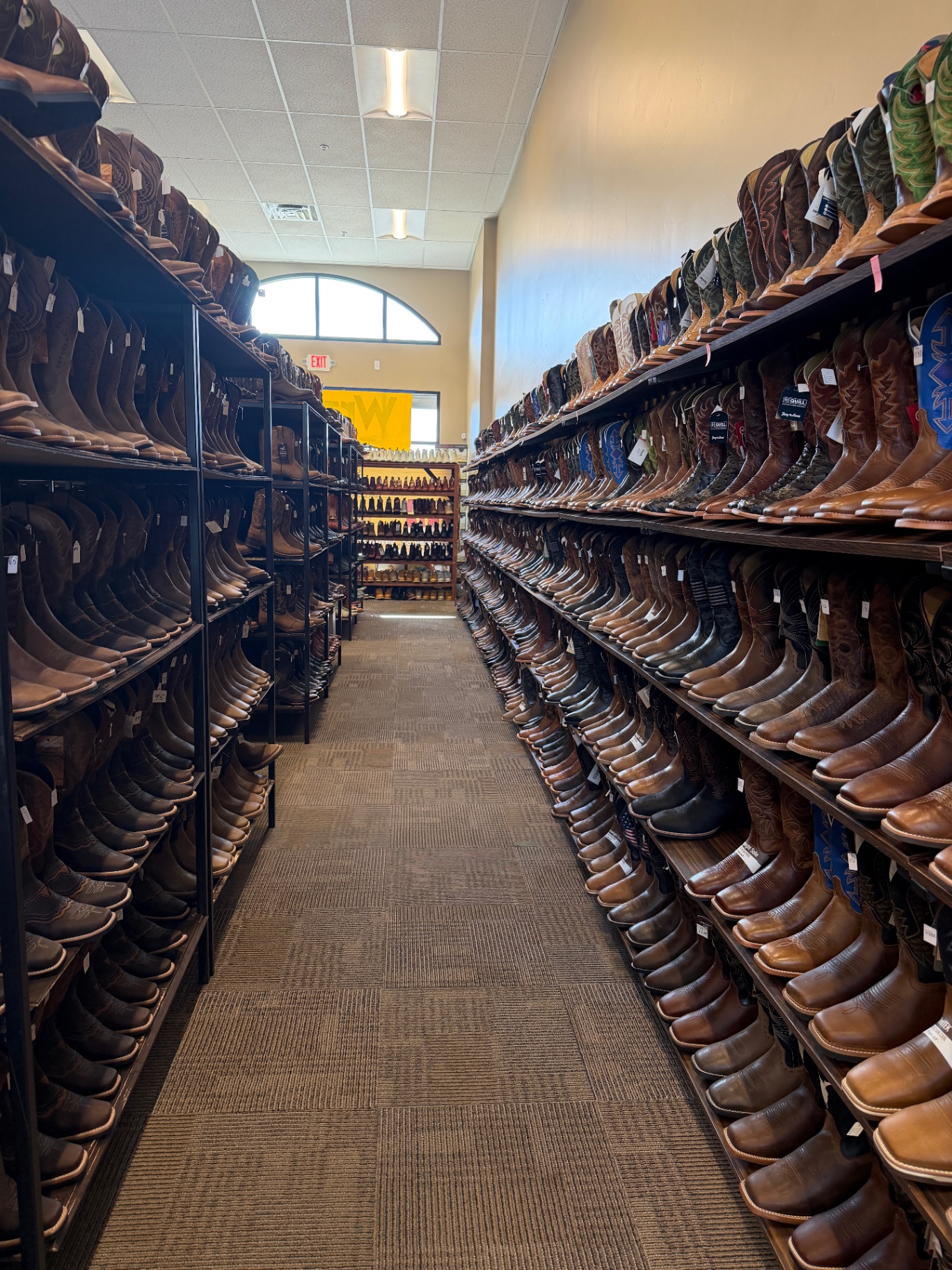 Cowboy boots and hats lined up inside Santa Maria Western Wear